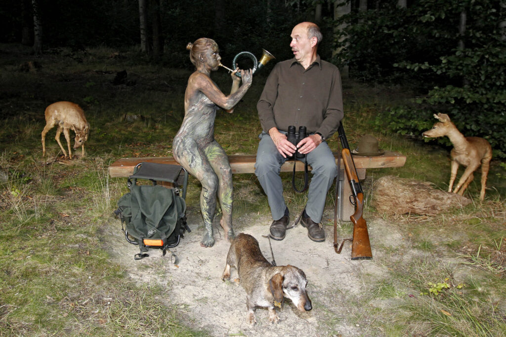 Für das Projekt Workingart wurde ein nacktes Fotomodell von Künstler Jörg Düsterwald vollständig mit einem Baummuster bemalt. Die Frau sitzt zusammen mit einem Jäger auf einer Bank im Wald. Sie bläst in ein Horn, der Jäger guckt erstaunt. Ein Dackel, ein Gewehr, ein Rucksack, ein Fernrohr sowie zwei Rehe ergänzen die Szene.
