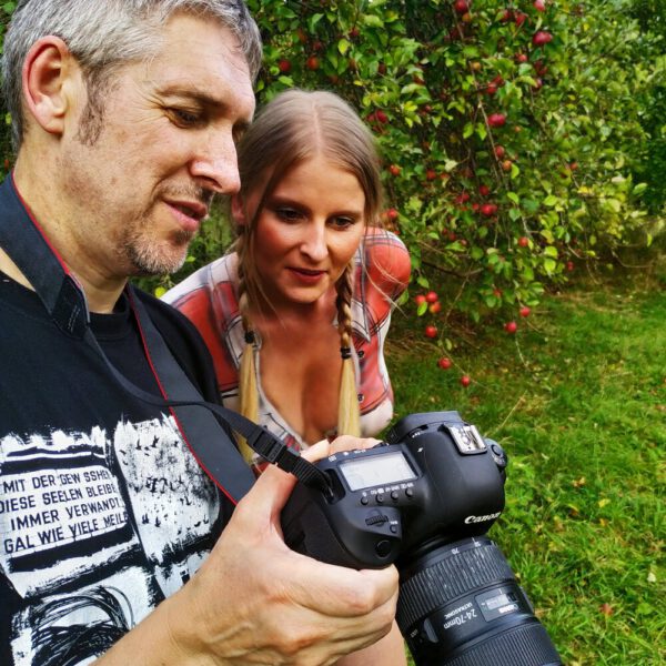 Im Rahmen des Kunstprojektes AGRAR ART hat Bodypaint-Künstler Jörg Düsterwald ein nacktes Fotomodell mit Körperfarbe so bemalt, als hätte die Frau eine kurze blaue Hose und ein rotweiß-kariertes Hemd an. Sie befindet sich in einer Apfelbaumplantage und erntet die Äpfel.