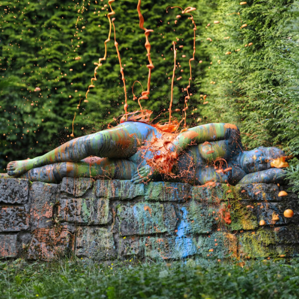 Für das Outdoor-Projekt SPLASH ART hat Künstler Jörg Düsterwald ein unbekleidetes Fotomodell mit Körperfarbe bemalt und anschließend in einer Landschaft mit flüssiger Farbe übergossen.
