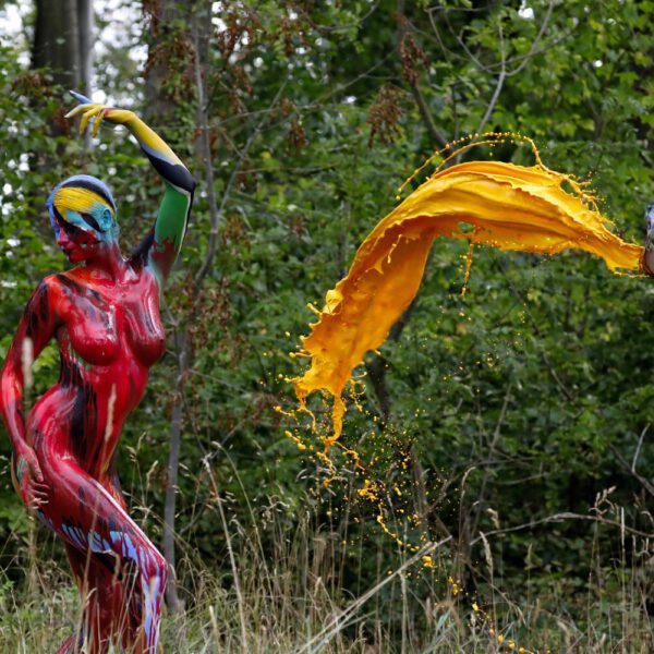 Für das Outdoor-Projekt SPLASH ART hat Künstler Jörg Düsterwald ein unbekleidetes Fotomodell mit Körperfarbe bemalt und anschließend in einer Landschaft mit flüssiger Farbe übergossen.