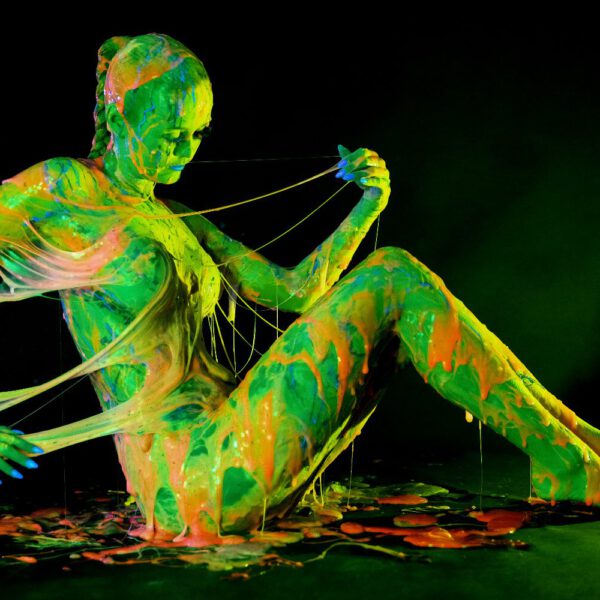 Künstler Jörg Düsterwald und Fotograf Alexander Große-Strangmann haben für ein experimentelles Fotoshooting ein nacktes Fotomodell erst vollständig mit Bodypaintingfarbe bemalt und dann mit glibberigem Schleim versehen. Mit der Masse posiert die Frau in einem Fotostudio vor der Kamera.