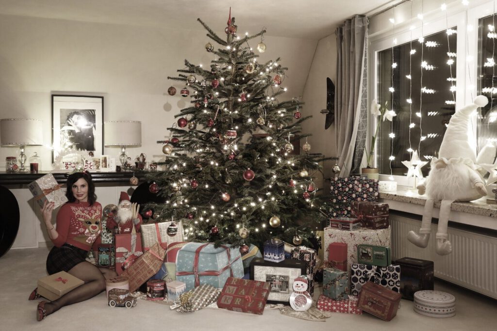 Künstler Jörg Düsterwald hat auf dem Rücken eines Fotomodells die Illusion eines Weihnachtsgeschenks gemalt. Die Frau liegt unter einem geschmückten Weihnachtsbaum, Moderatorin Dany Michalski sitzt daneben und entdeckt überrascht das Paket.