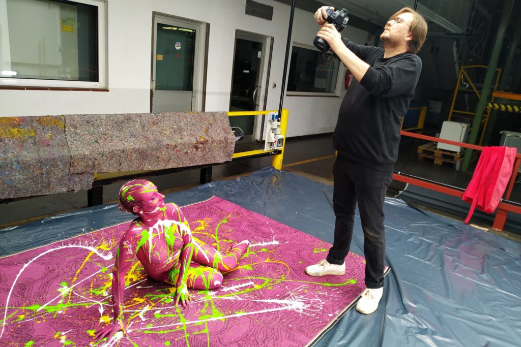 Mit flüssiger Farbe, einem bemalten Fotomodell und einem Bodenbelag als Grundlage hat Künstler Jörg Düsterwald sowohl einzigartige Fotobildwerke wie auch ein Teppichdesign als exklusives Unikat kreiert.
