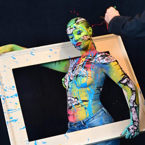 In einer Hamburger Galerie präsentiert Bodyart-Künstler Jörg Düsterwald mit seinem Fotomodell live vor Publikum eine freestyle Kunstperformance. Er versieht sein halbnacktes Modell mit einer Körpermalerei und anschließend bekleckert er die Frau mit viel flüssiger Farbe. Ein Fernsehteam begleitet die Aktion.