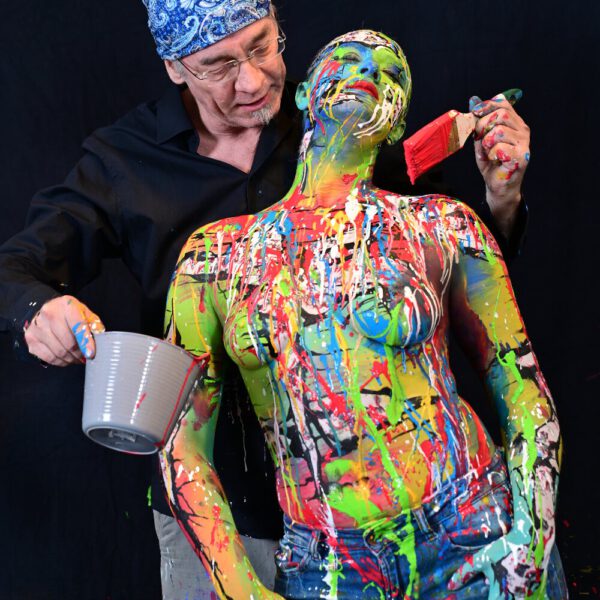 In einer Hamburger Galerie präsentiert Bodyart-Künstler Jörg Düsterwald mit seinem Fotomodell live vor Publikum eine freestyle Kunstperformance. Er versieht sein halbnacktes Modell mit einer Körpermalerei und anschließend bekleckert er die Frau mit viel flüssiger Farbe. Ein Fernsehteam begleitet die Aktion.
