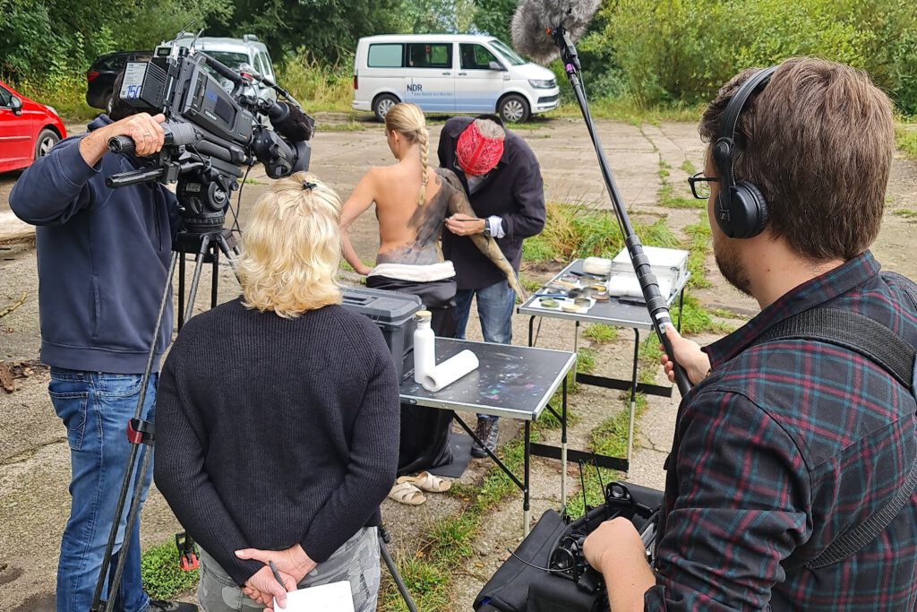 Ein Fernsehteam begleitet Künstler Jörg Düsterwald und sein Fotomodell bei der Realisierung eines Motives für sein Kunstprojekt Mensch und Natur - Farbige Symbiosen.