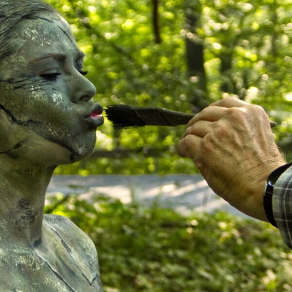 Ein nacktes Fotomodell wird für das Kunstprojekt Natureart von Künstler Jörg Düsterwald vollständig so mit Farbe bemalt, dass die Person mit der Kulisse verschmilzt.