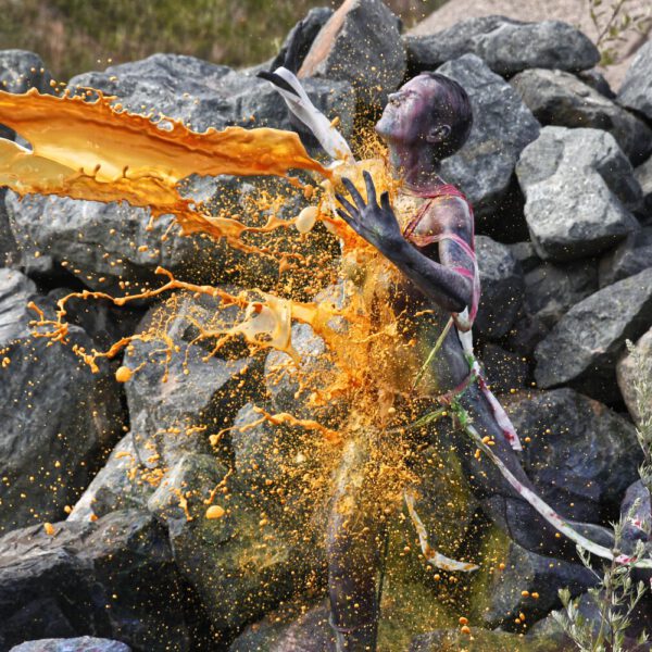 Für das Outdoor-Projekt SPLASH ART hat Künstler Jörg Düsterwald ein unbekleidetes Fotomodell mit Körperfarbe bemalt und anschließend in einer Landschaft mit flüssiger Farbe übergossen.