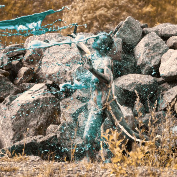 Für das Outdoor-Projekt SPLASH ART hat Künstler Jörg Düsterwald ein unbekleidetes Fotomodell mit Körperfarbe bemalt und anschließend in einer Landschaft mit flüssiger Farbe übergossen.